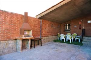 un patio extérieur avec des chaises et un poêle à bois dans l'établissement Casa Rural EL HUERTO con Jardín, à Lumbrales