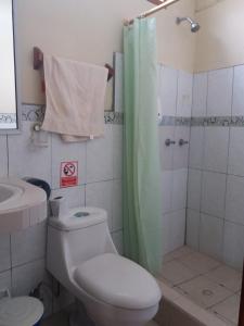 a bathroom with a toilet and a shower at Hostal Miconia in Puerto Ayora