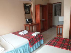 Habitación de hotel con cama y espejo en Hostal Miconia en Puerto Ayora