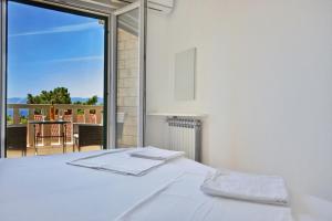 a bedroom with a bed and a view of a balcony at Guest House Marija in Bol