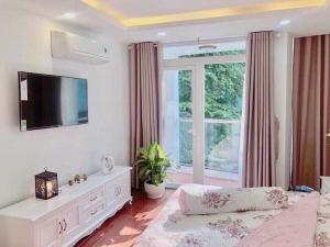 - un salon avec un lit et une grande fenêtre dans l'établissement Tropical House, à Hô-Chi-Minh-Ville