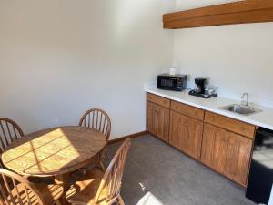 a kitchen with a table and chairs and a sink at Farmstead Inn and Conference Center in Shipshewana