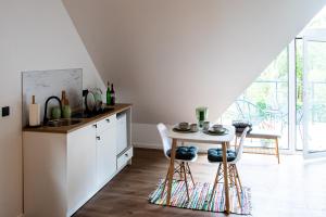 a kitchen with a small table and a sink at Vakaras cozy apartment in the guest house with the terrace and the stunning view to the river side in Birštonas