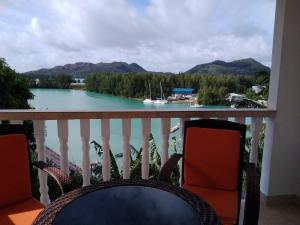 uma varanda com vista para a água e para as montanhas em Belle Rose Vue guest house em Baie Sainte Anne