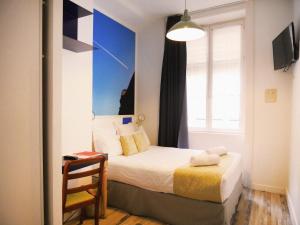 a small bedroom with a bed and a window at Hôtel du Simplon in Lyon