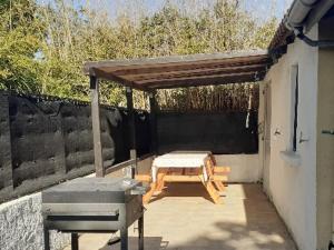 eine Terrasse mit einem Picknicktisch und einem Dach in der Unterkunft les papyrus avec draps in Arles