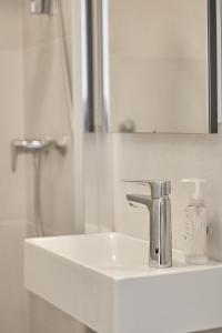 a bathroom sink with a faucet and a mirror at Guest House Marija in Bol