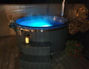 a jacuzzi tub in a backyard at night at KK Apartment in Ventspils
