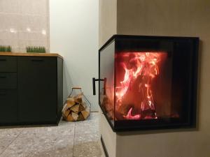 a television with a fire in it in a room at KK Apartment in Ventspils