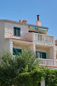 a large brick house with a balcony on top of it at Guest House Marija in Bol