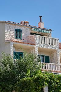 Una gran casa de ladrillo con un balcón en la parte superior. en Guest House Marija, en Bol