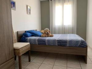 un osito de peluche sentado en una cama en un dormitorio en Maison Balaruc-les-Bains, 3 pièces, 4 personnes - FR-1-503-126, en Balaruc-les-Bains