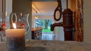 una vela sentada sobre una mesa junto a un vaso en Les Highlands - Maison de vacances, en Houffalize