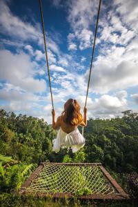 Ein junges Mädchen, das auf einem Seil schwingt in der Unterkunft Bubble Hotel Bali Ubud - Adults Only in Gianyar
