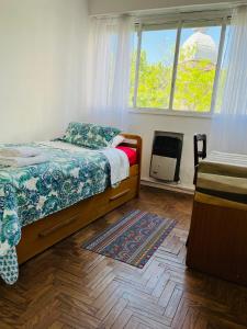 een slaapkamer met een bed en een raam bij Mira Bosques 2 in La Plata