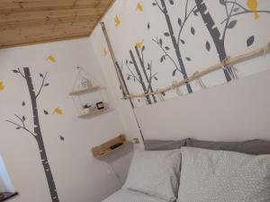 a bedroom with a tree mural on the wall at B&B Alle Betulle in Pievepelago