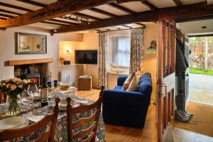 a living room with a blue couch and a table at Finest Retreats - The Cottage at Greystoke in Greystoke