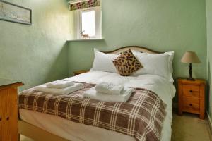 uma cama com duas almofadas e duas toalhas em Finest Retreats - The Cottage at Greystoke em Greystoke