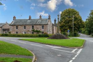 a house with a monument in the middle of a road at Finest Retreats - The Cottage at Greystoke in Greystoke