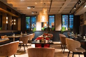 ein Restaurant mit Tischen, Stühlen und Fenstern in der Unterkunft The Highlander in Amsterdam