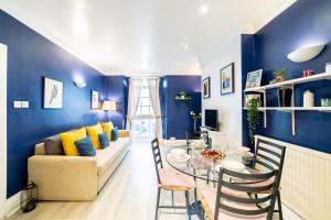 ein Wohnzimmer mit blauen Wänden, einem Tisch und einem Sofa in der Unterkunft ［Regent' S Park-Fitzrovia］Central London Apartment in London