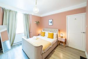 ein Schlafzimmer mit einem weißen Bett und gelben Kissen in der Unterkunft ［Regent' S Park-Fitzrovia］Central London Apartment in London