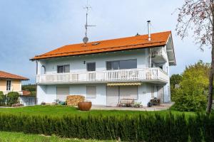 a large white house with an orange roof at FeWo Am Stocket in Gstadt am Chiemsee