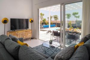 un salon avec un canapé gris et une télévision dans l'établissement SUNRISE by Buenavilla, à Playa Blanca