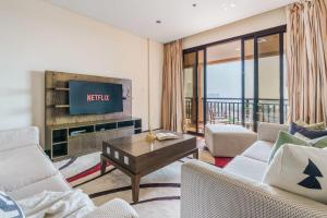 杜拜的住宿－GuestReady - Slice of Luxury in Palm Jumeirah，一间带电视和沙发的客厅