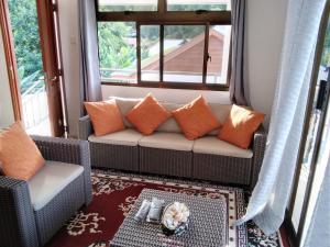 uma sala de estar com um sofá e uma janela em Belle Rose Vue guest house em Baie Sainte Anne