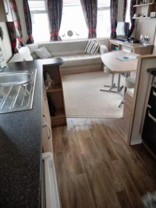 a living room with a couch and a table at Swift Loire (Field view 78) in Jaywick Sands +2 photos