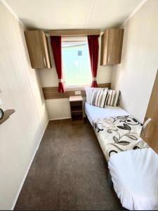 a small room with two beds and a window at Swift Loire (Field view 78) in Jaywick Sands