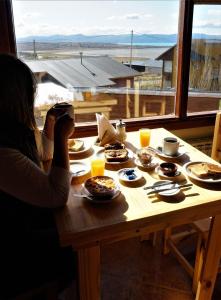 a woman taking a picture of a table with food at Ruca Nel in El Calafate +32 photos