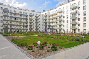 a garden in front of a large apartment building at Downtown Apartments City Center Angielska Grobla in Gdańsk