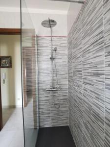 La salle de bains est pourvue d'une douche et d'une paroi en verre. dans l'établissement Lorenzo Guest Suite - Cantieri culturali- Garage privato al coperto gratuito, à Palerme
