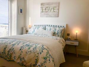 1 dormitorio con cama con colcha y signo de amor en Sunsets, Sandylands Prom Morecambe, en Morecambe