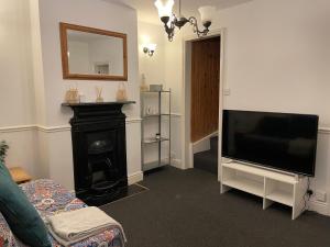 sala de estar con TV de pantalla plana y chimenea en Cozy 3 Bedrooms Home off Mill Road Sleep up to 6, en Cambridge