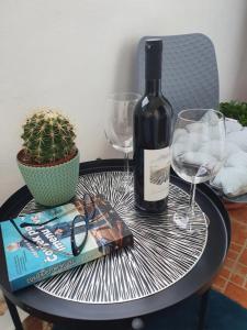 a bottle of wine sitting on a table with a book and glasses at Little Sea Stars, Tivat in Tivat