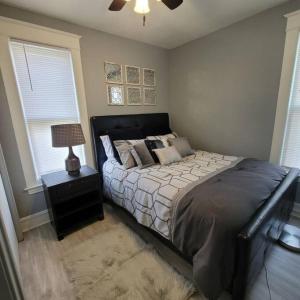 een slaapkamer met een bed en een nachtkastje met een lamp bij Retreat Suite 4 - Downtown Getaway in Grand Rapids