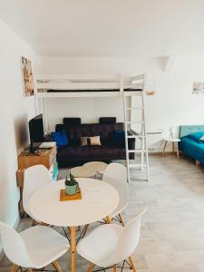 a living room with a table and chairs and a bunk bed at Le pressoir de gisay in Gisay