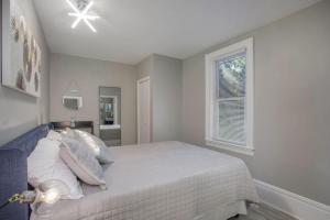 a white bedroom with a bed and a window at Stunning Couples Retreat - Downtown Getaway in Grand Rapids