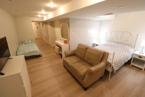 a bedroom with a bed and a couch and a chair at Best, Prime location! Next to Vaughan mills! in Vaughan