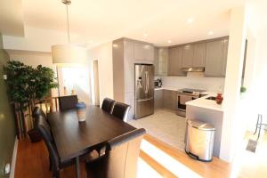 a kitchen with a wooden table and a dining room at Best, Prime location! Next to Vaughan mills! in Vaughan