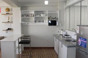 a kitchen with a sink and a microwave at Mercé Hotel in Tacna
