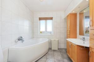 a white bathroom with a tub and a sink at Flemsøy in Ålesund