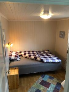 1 dormitorio con 1 cama con manta a cuadros en Flemsøy en Ålesund