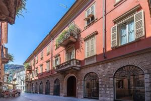 een groot roze gebouw met ramen en een straat bij [Old Town] Lake Como - Sweet Apartment in Como