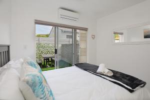 um quarto com uma cama branca e uma janela em Say Shells em Cidade do Cabo