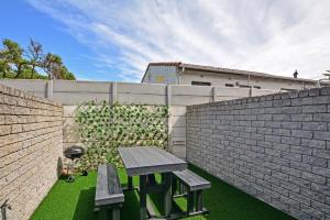 a retaining wall with two benches and a fence at Say Shells in Cape Town