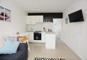 a living room with a couch and a kitchen at Say Shells in Cape Town